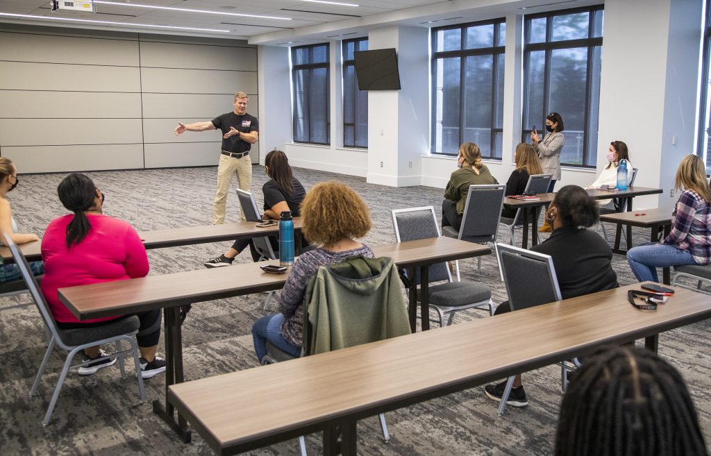 Man speaking to class of women