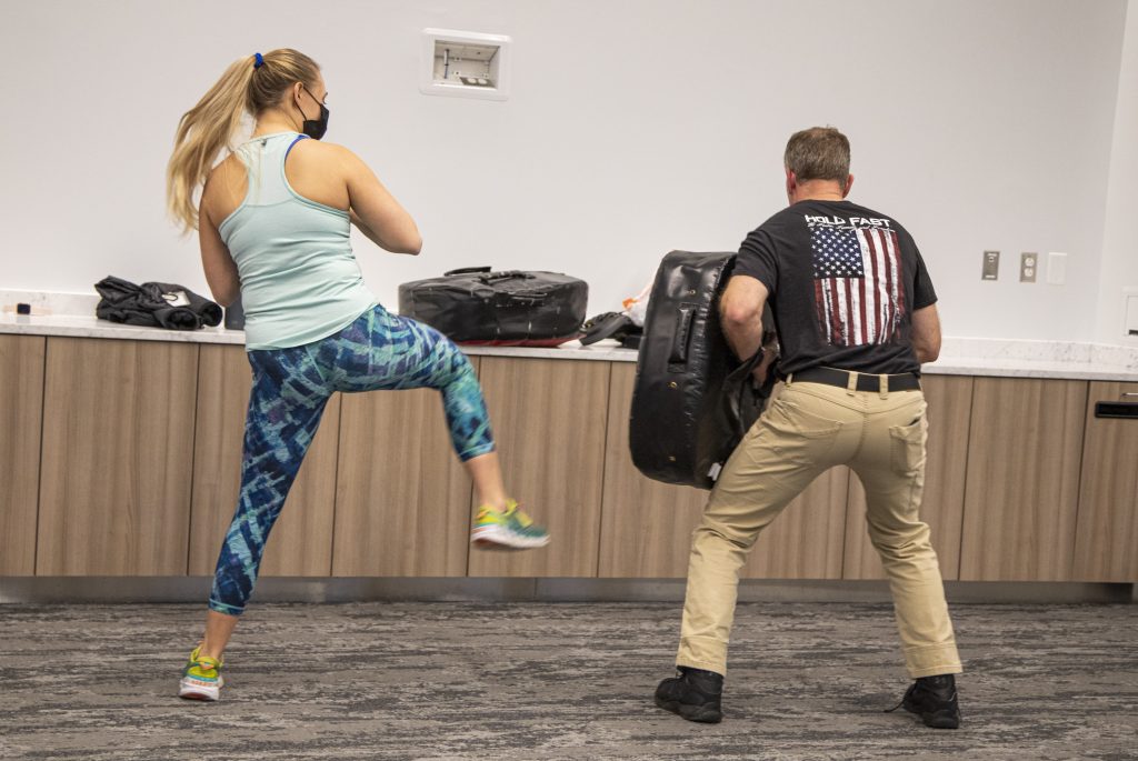 woman kicking pad for self defense practice