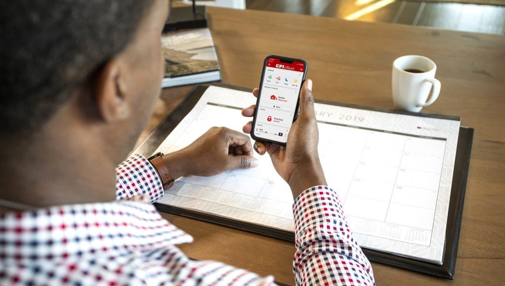 Person using the CPI inTouch mobile security app on a smartphone at work