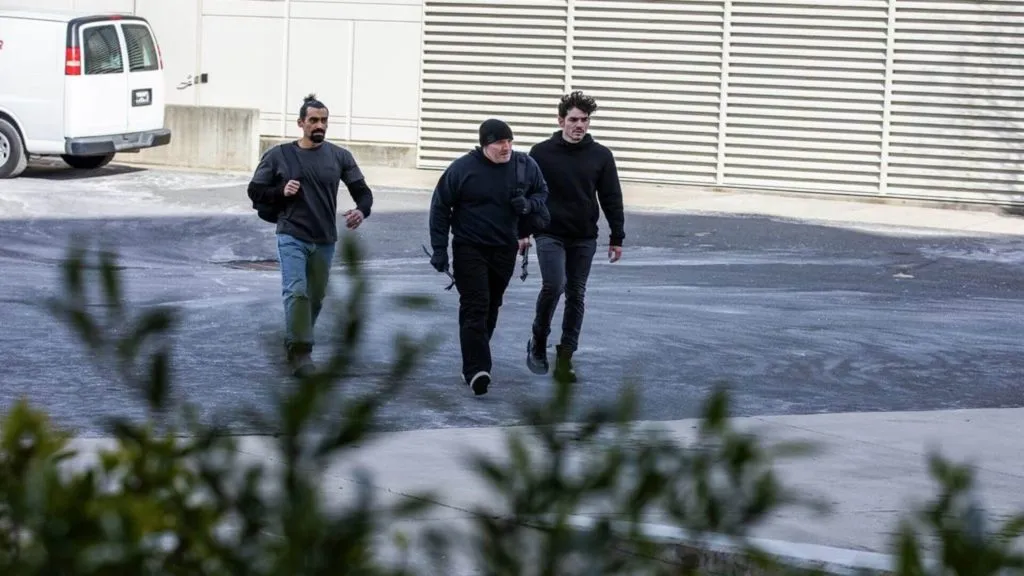 Three burglars approaching a business