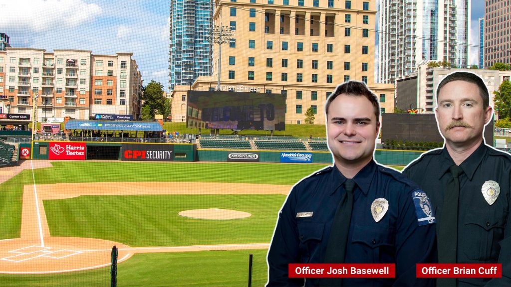 Police officers pose next to baseball field