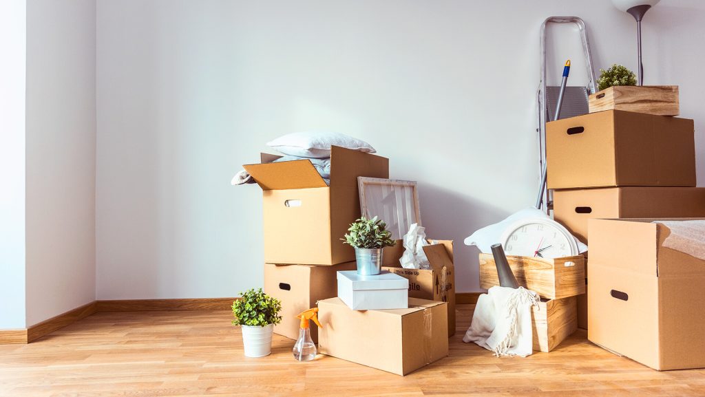 Moving boxes piled up in corner of empty room
