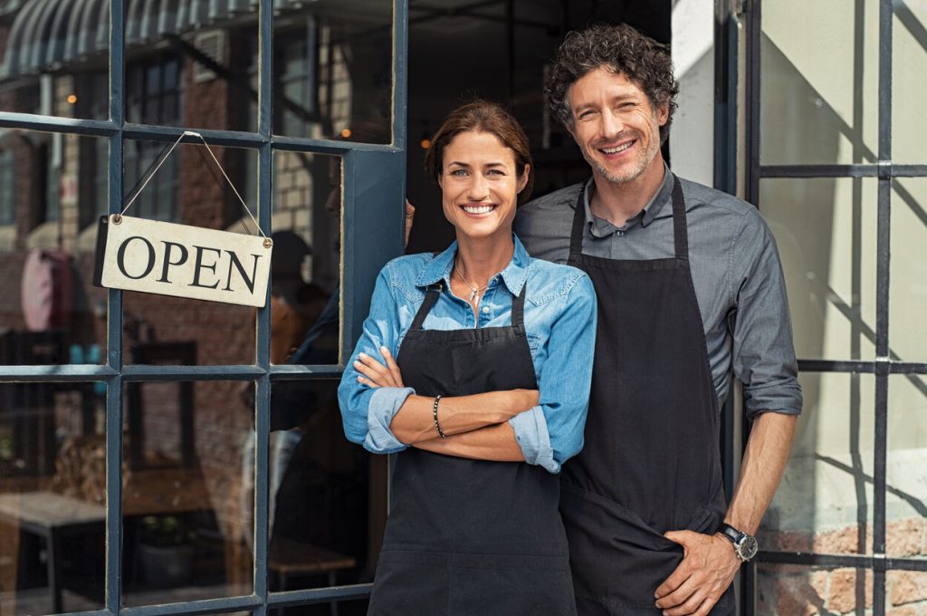 Small business owners in front of open restaurant