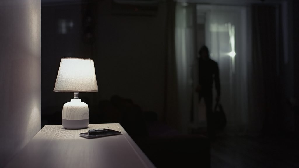 Dark room in house with shadowy figure in the background
