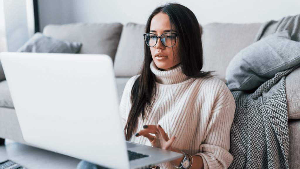 Woman sitting on living room floor on laptop