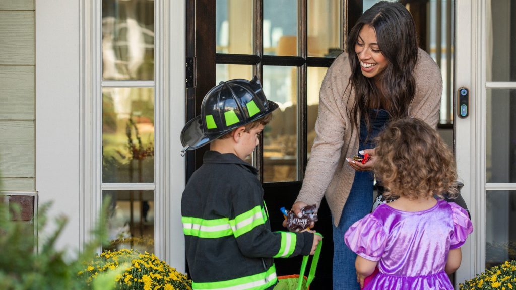 Lady giving candy to trick o treaters