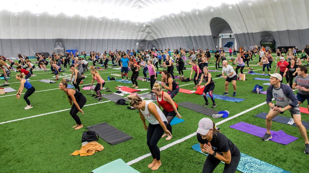 Large group participating in outdoor yoga class