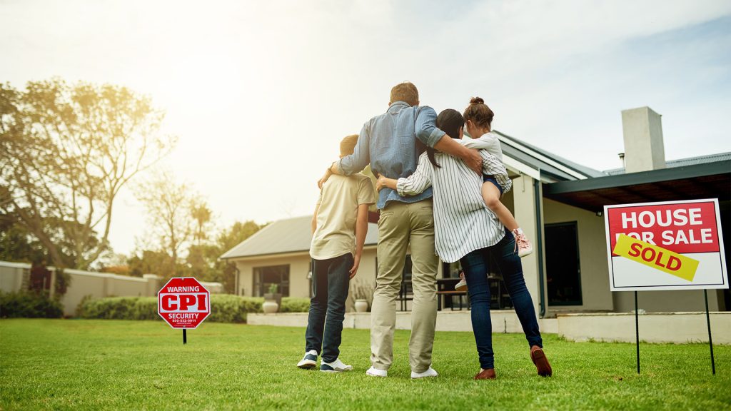 Family moving into new home with Sold sign in the front yard