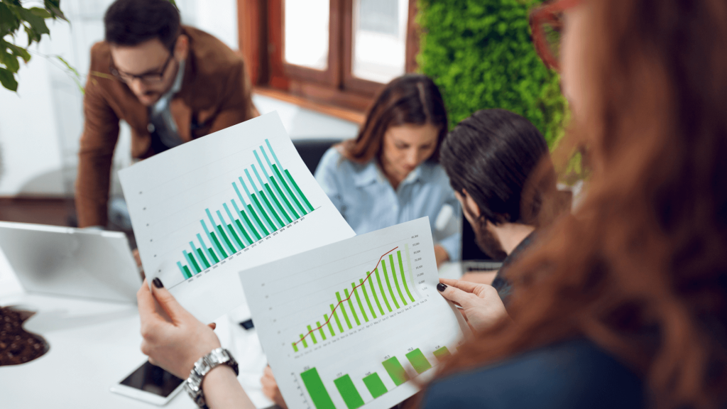 Woman holding up printed graphs and charts during business meeting