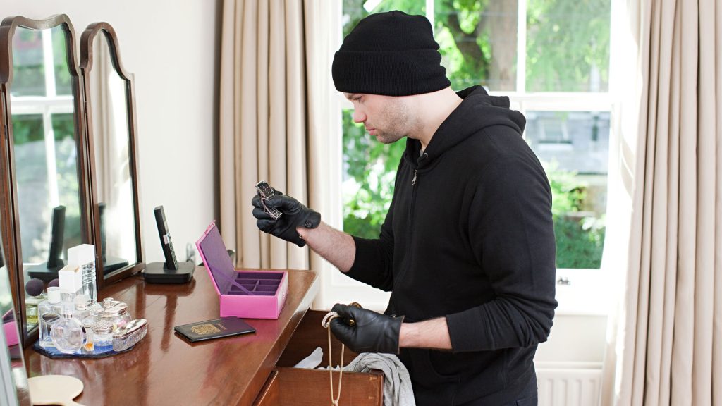 Burglar looking through valuables in home