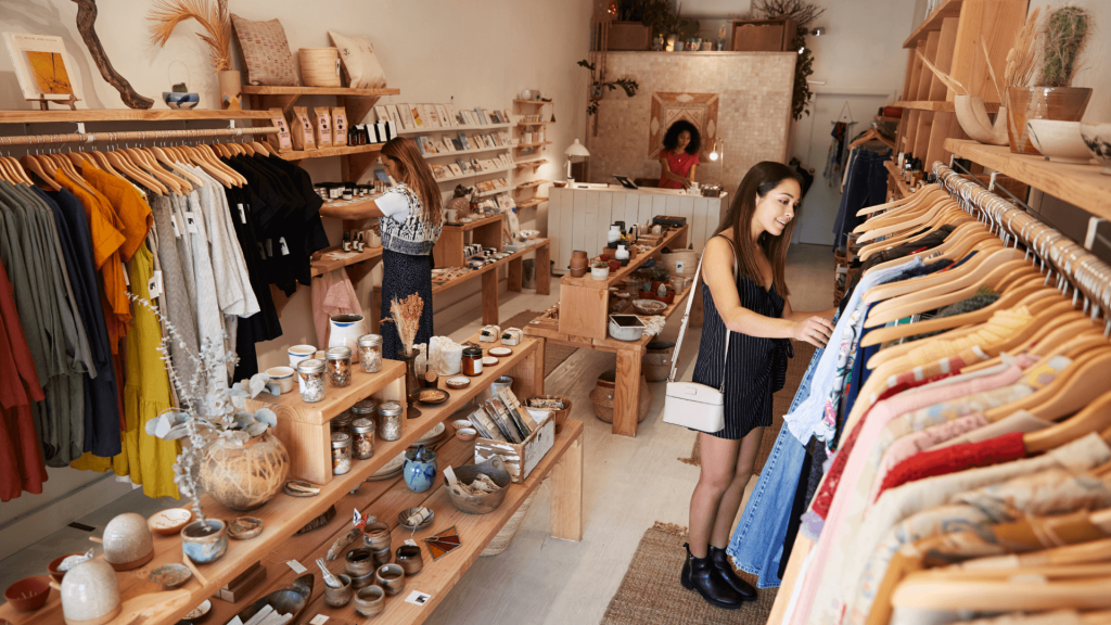 women looking through clothing racks at retail store