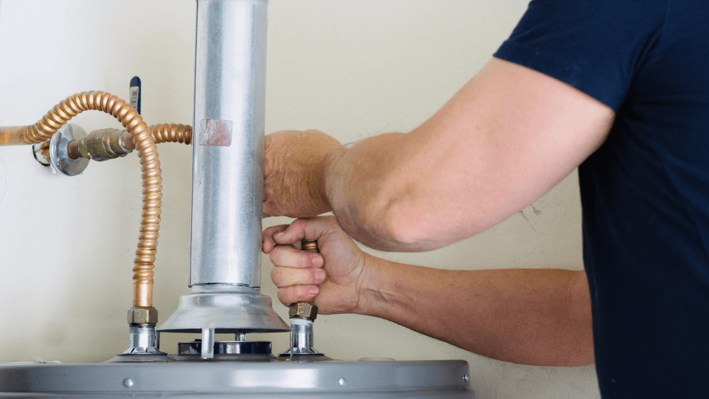 Person pulling pipes from water heater