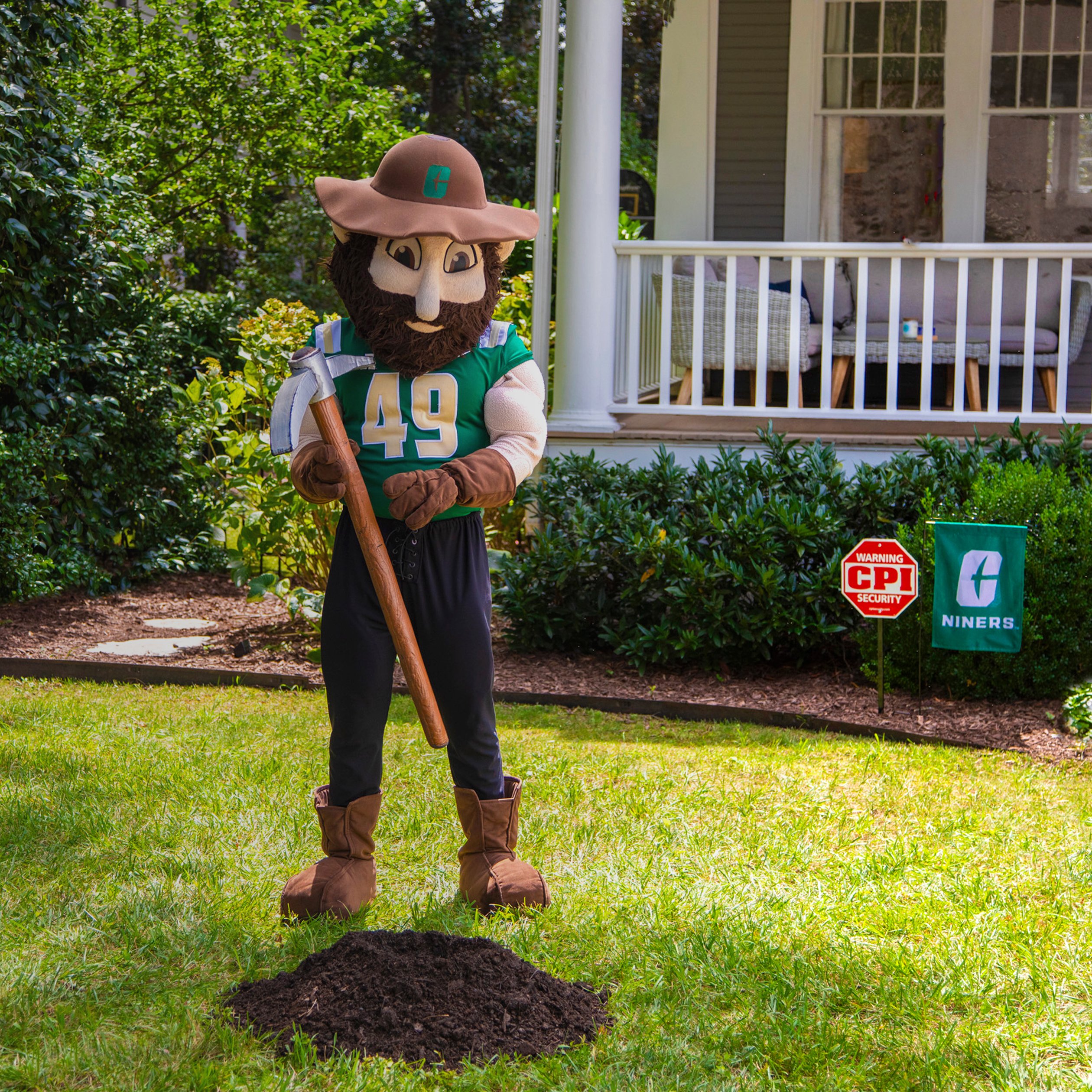 Charlotte 49ers mascot standing in front of home with CPI Security yard sign