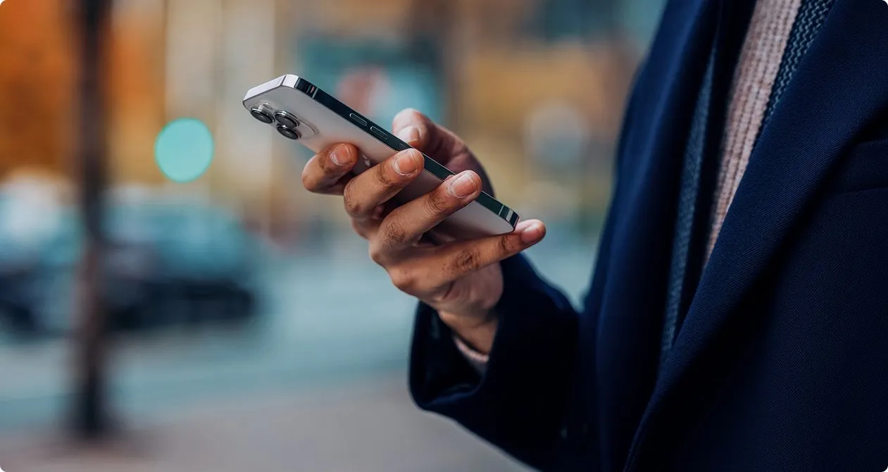 Business professional in blue suit looking at iPhone