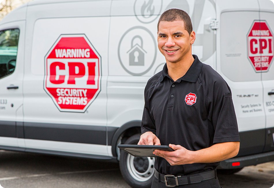 CPI Security Technician standing in front of van holding an ipad