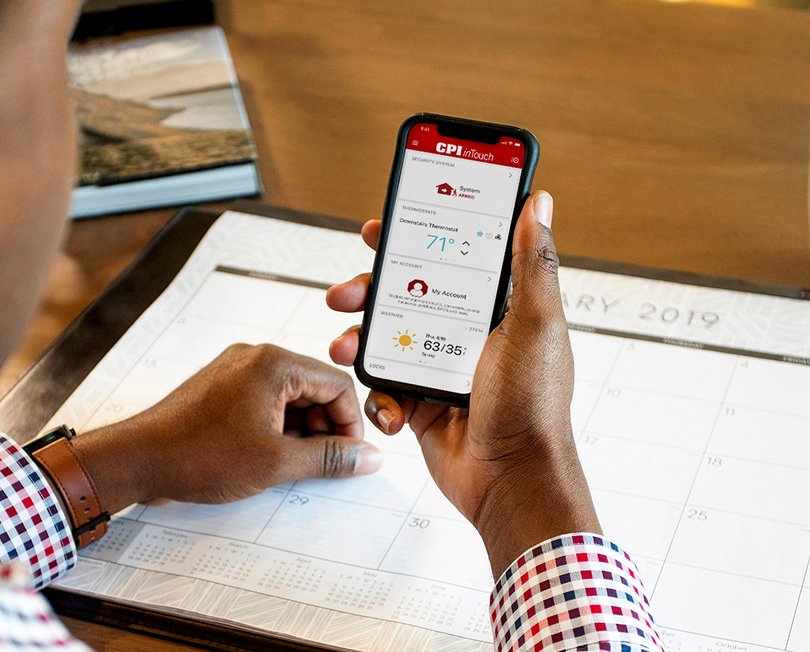 Person holding iPhone displaying inTouch app dashboard