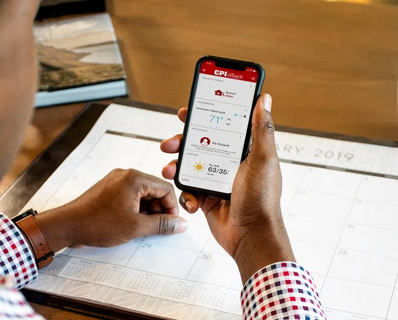 Person holding iPhone displaying inTouch app dashboard