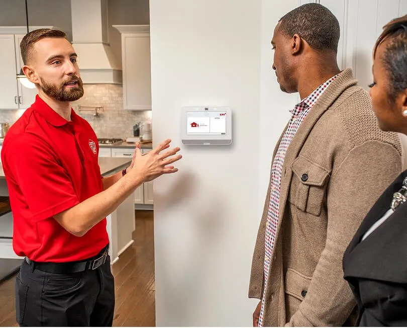 CPI Security technician showing customers how to operate SmartHub mounted on wall